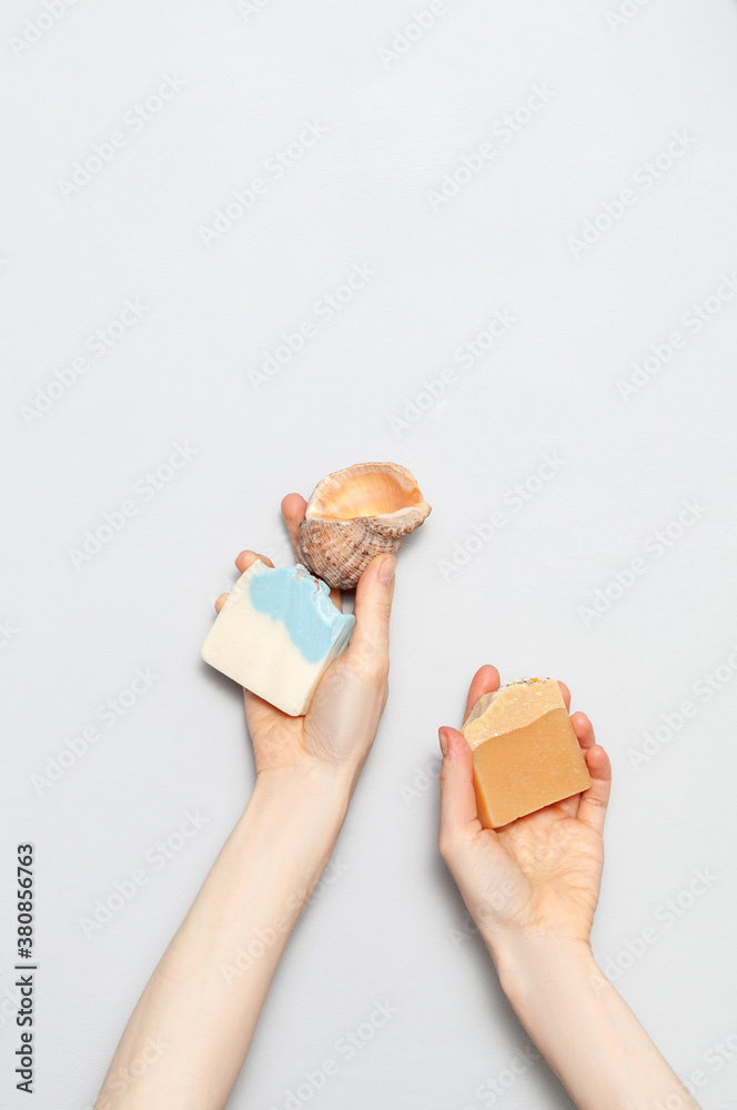 Woman holding natural handmade soap bar on white cloth background