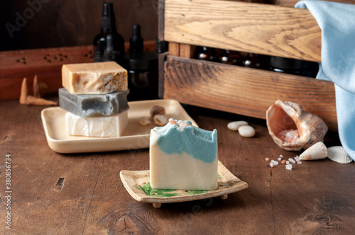 Obraz na płótnie Natural handmade soap bar in ceramic soap dish with spa accessories on wooden table w salonie