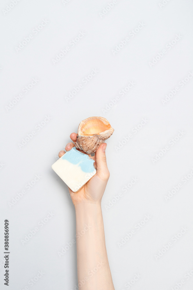 Woman holding natural handmade soap bar on white cloth background