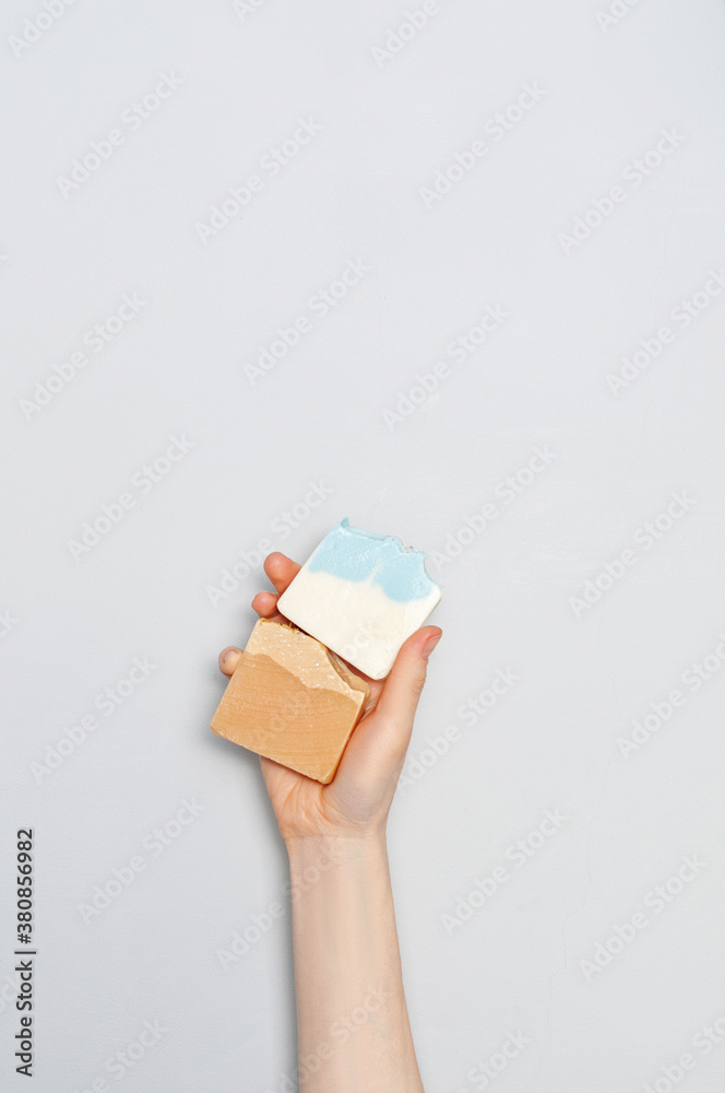 Woman holding natural handmade soap bar on white cloth background