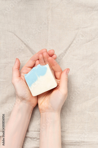Obraz na płótnie Woman holding natural handmade soap bar on linen fabric background w salonie