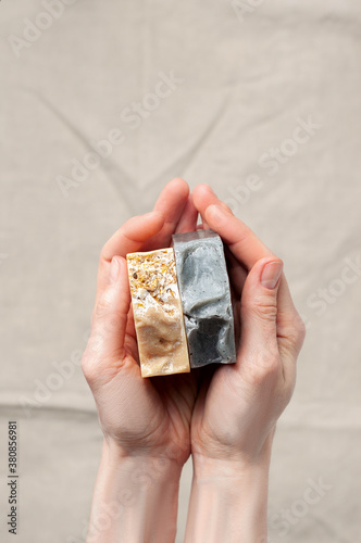 Obraz na płótnie Woman holding natural handmade soap bar on linen fabric background w salonie