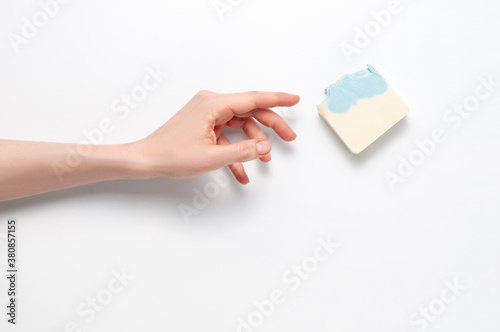 Woman holding natural handmade soap bar on white cloth background