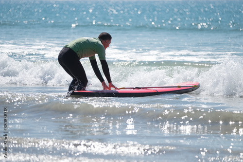 Man about to enter the ocean on a SUP photo