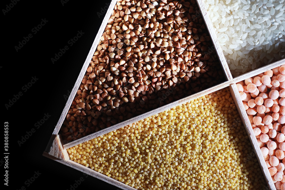 A set of grain cereals. Rice, buckwheat and millet groats in a wooden tray. A grocery set of cereals. Import of grain. A set of grain cereals. Rice, buckwheat and millet groats in a wooden tray. A grocery set of cereals. Import of grain.