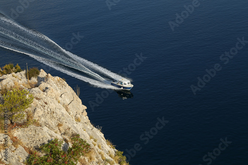 Fishing boat with motor glides on the surface of the lake photo