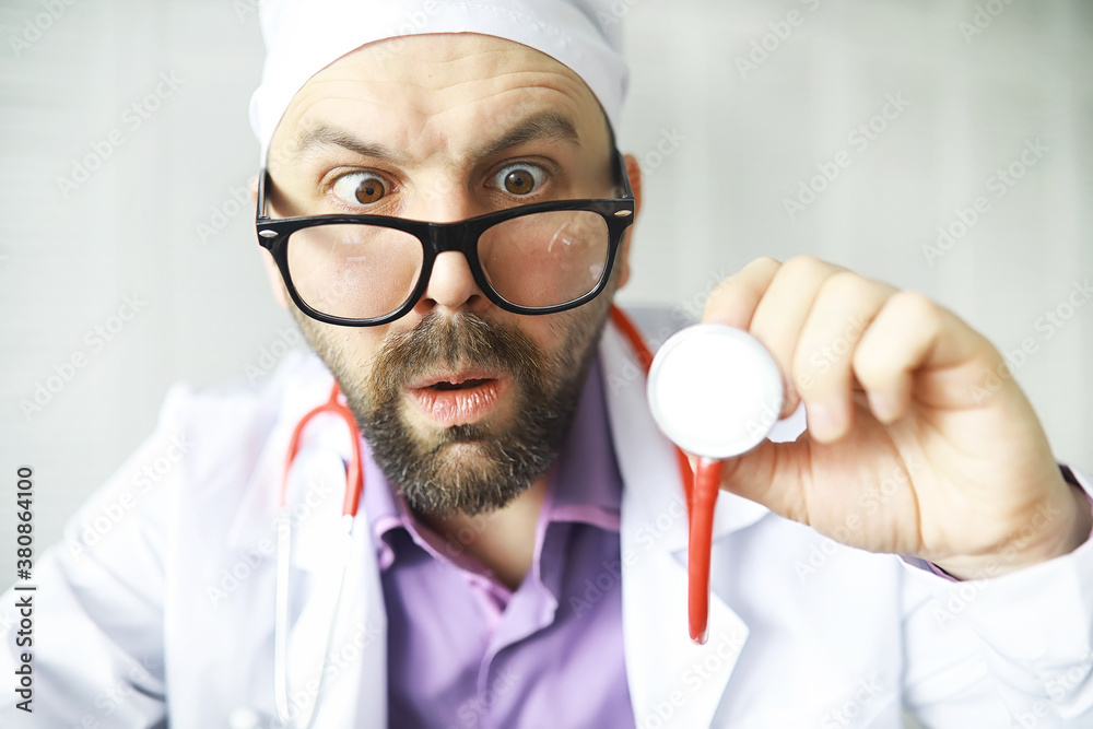 A cross-eyed bearded man is looking into the frame. Eye disease. The concept of a crazy medical specialist. Doctor neighbor. A cross-eyed bearded man is looking into the frame. Eye disease. The concept of a crazy medical specialist. Doctor neighbor.