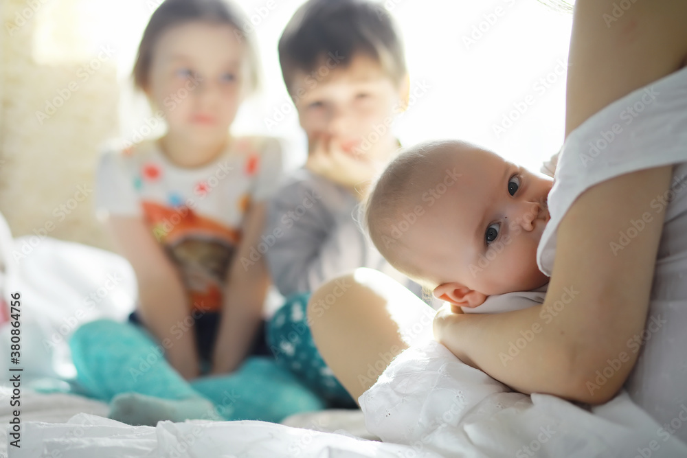 Maternity concept. A young mother feeds her little baby. First lure and breastfeeding. Family in white clothes. Maternity concept. A young mother feeds her little baby. First lure and breastfeeding. Family in white clothes.