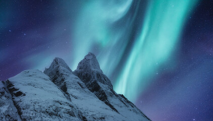 Aurora borealis on Lofoten islands, Norway. Green northern lights above mountains. Night winter landscape with aurora. Natural background in the Norway.
