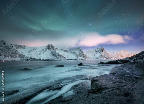 Aurora borealis on Lofoten islands, Norway. Green northern lights above mountains. Night winter landscape with aurora. Natural background in the Norway.