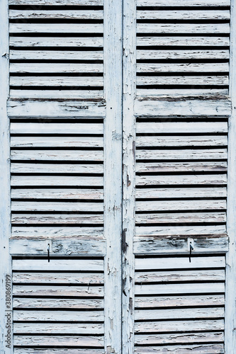 Close-up of wooden shutters with peeled paint.