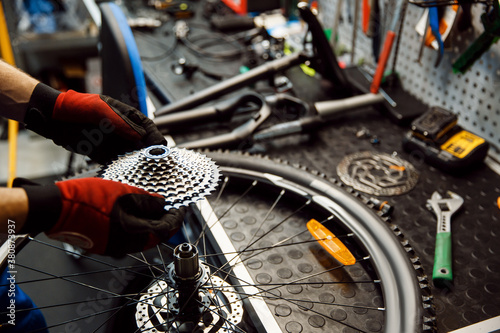 Tableau sur Toile Bicycle repair in workshop, man installs cassette