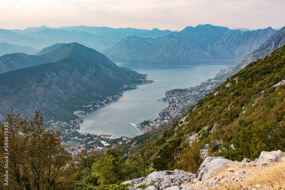 Panorama of Kotor bay and city from mountain road. Beautiful view to Kotor city with lovely architecture, hotwls and boats in the sea.