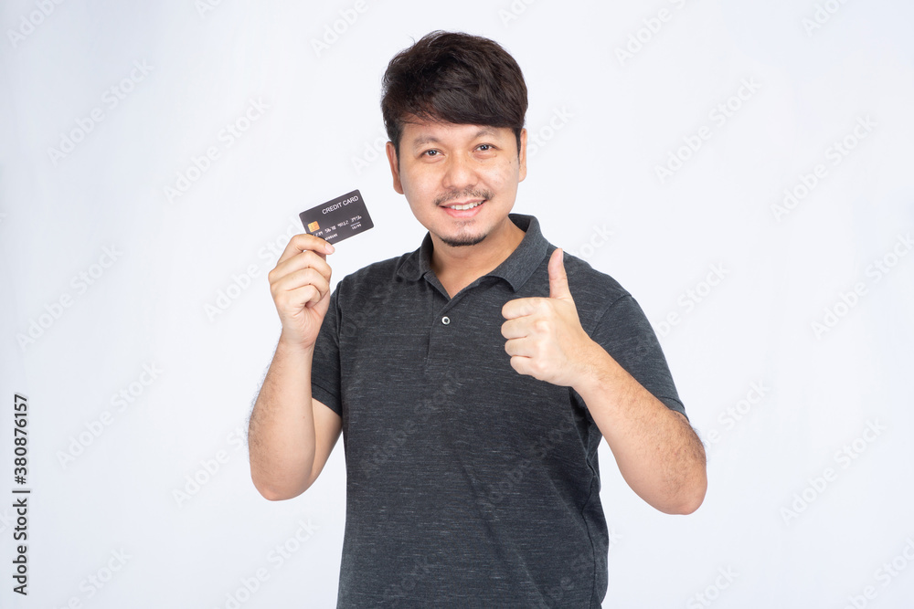 Happy Asian man in the smile face holding a credit card, thumbs up, look at the camera, credit card concept Happy Asian man in the smile face holding a credit card, thumbs up, look at the camera, credit card concept
