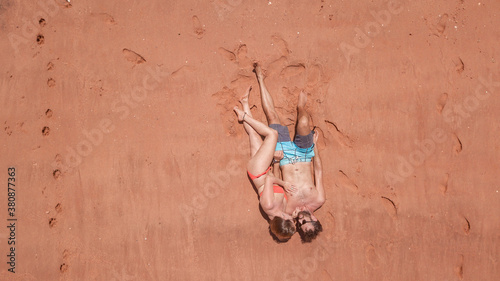 Couple lying on red sand beach
