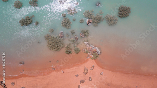 Drone view of red sand beach and turquoise water