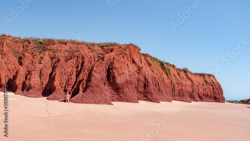 Woman sitting at a red sand dune