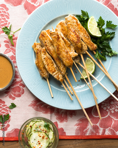 Thai chicken sate skewers with lime, parsley and cucumber photo