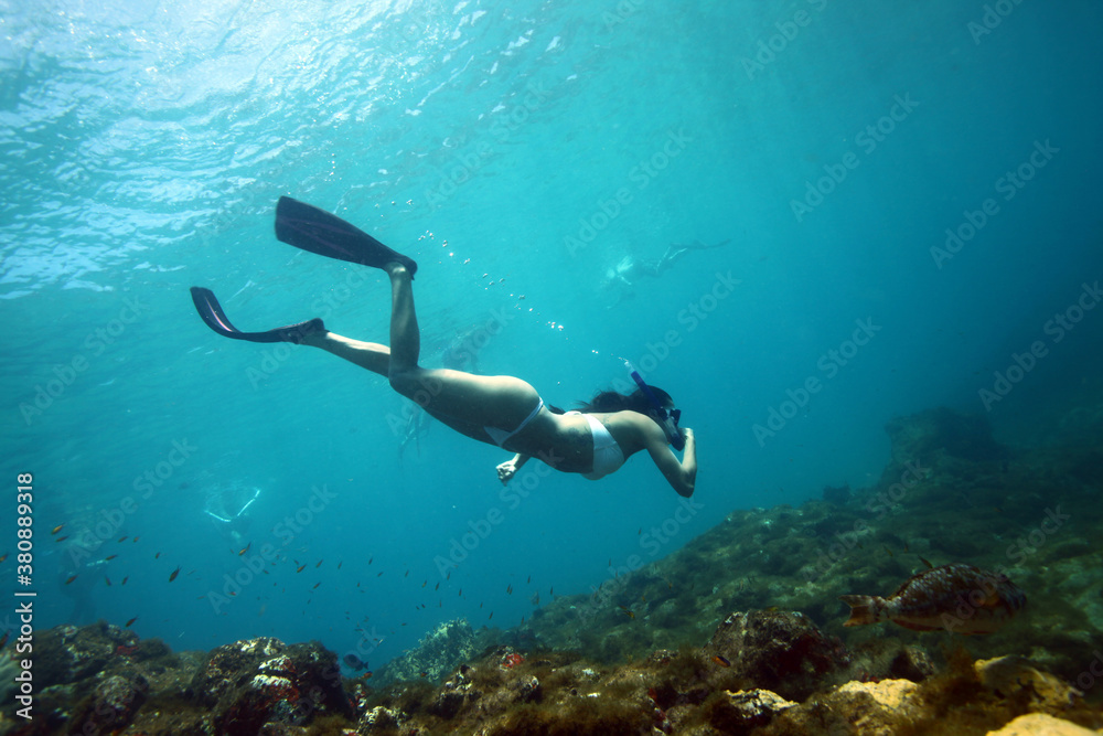 Beautiful woman snorkeling underwater in the sea, Brazil.