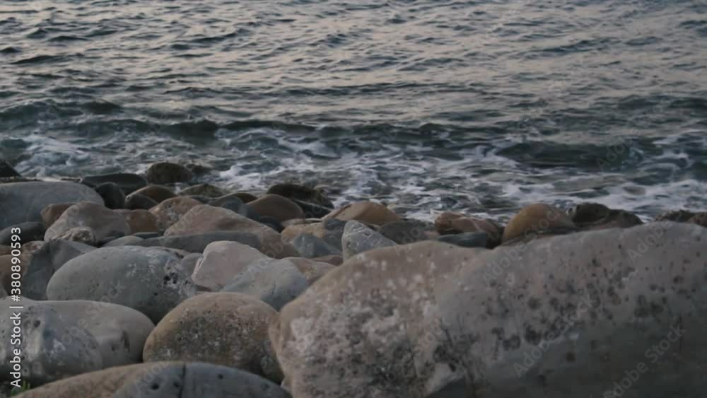 Calm waves in a beach of stones. Calm waves in a beach of stones.