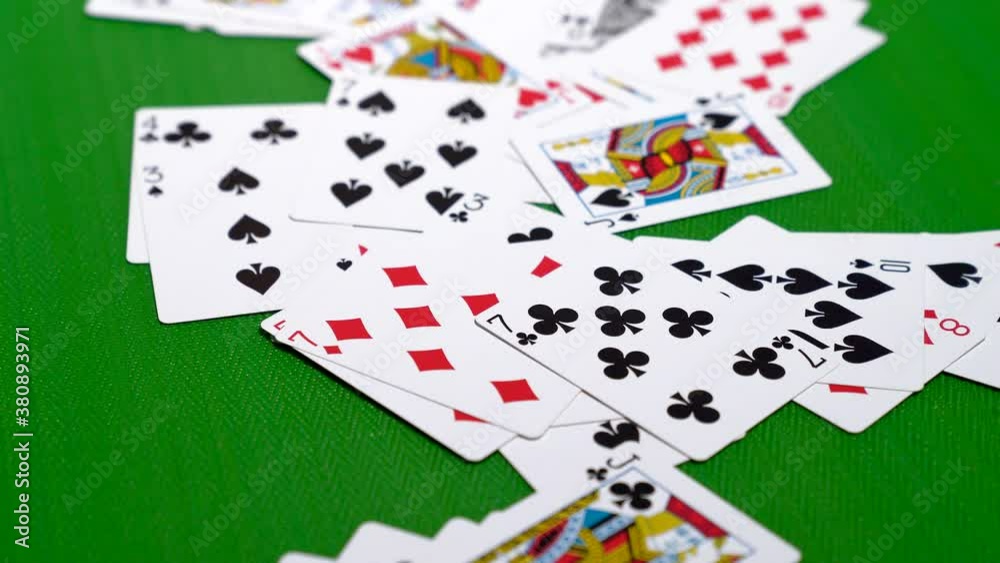 A pile of poker cards facing up being pushed into frame on a poker table in 4K A pile of poker cards facing up being pushed into frame on a poker table in 4K