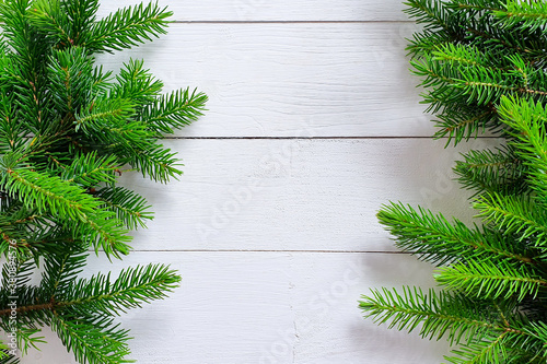 Fir / pine borders on white wooden background. Top view of Christmas frame, place for your text or product. Close-up, Christmas flatlay
