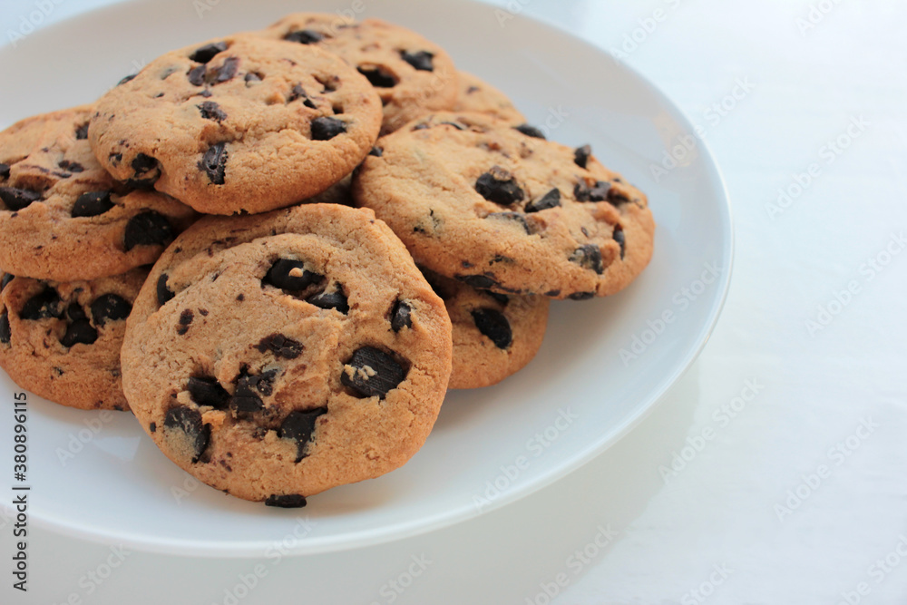 Fresh baked chocolate chip cookies on white background. View from above. Copy space. Selective focus
Fresh baked chocolate chip cookies on white background. View from above. Copy space. Selective focus