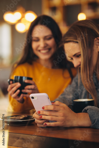 Friends using a smart phone at coffee shop