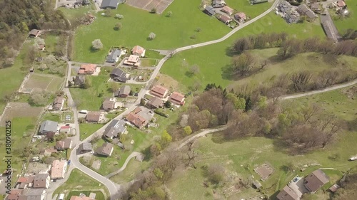 Aerial drone shot over the homes and buildings of Lavey Les Bains underneath a tall snowy mountain peak in Switzerland. photo