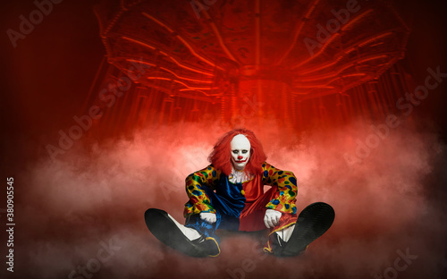 expressionless clown against the abstract background of an amusement park