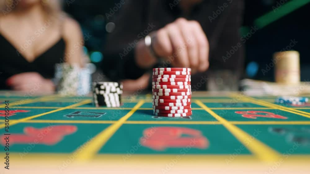 casino, gambling, poker, people and entertainment concept - close up of poker player with chips at green casino table