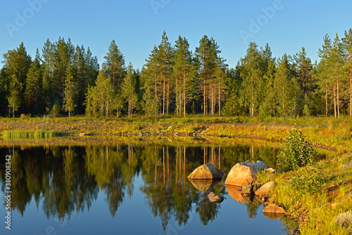 Sunny evening on northern forest lake. Finnish Lapland photo