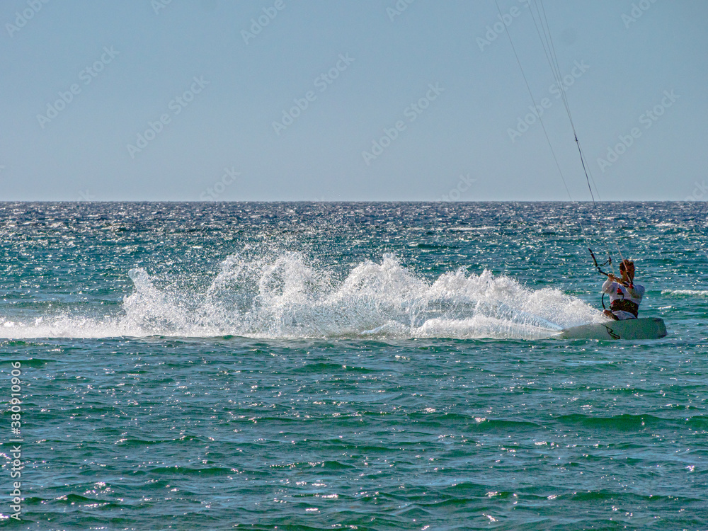 Obraz premium Kite Surfing through the afternoon sun with silhouette contours