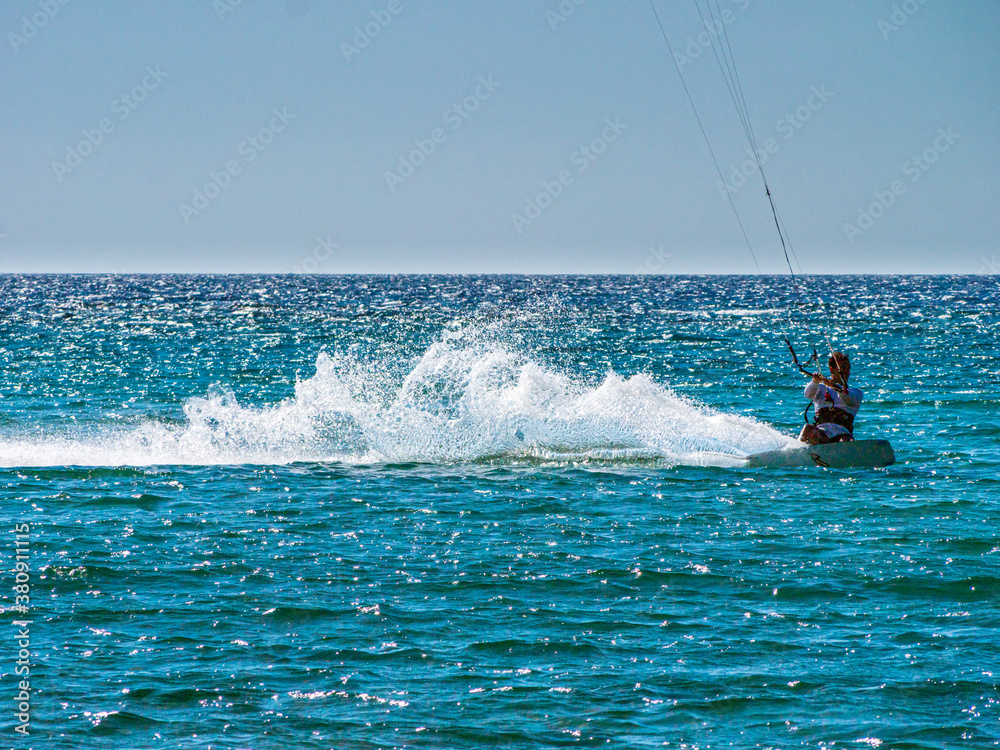 Obraz premium Kite Surfing through the afternoon sun with silhouette contours