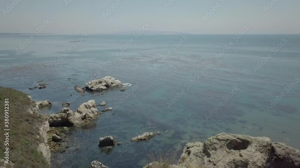 Avila Beach Pirate's Cove Cliffs. Ocean littered with seaweed. California Pacific Cliffs. Avila Beach Pirate's Cove Cliffs. Ocean littered with seaweed. California Pacific Cliffs.