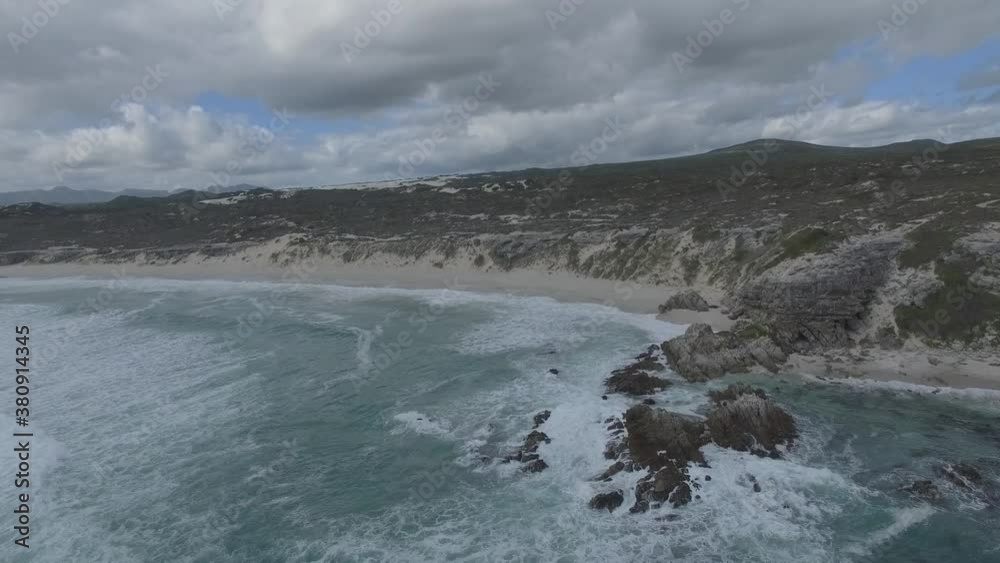 Aerial shot of people standing on the rocks next to the Ocean and Klipgat Cave in South Africa Aerial shot of people standing on the rocks next to the Ocean and Klipgat Cave in South Africa