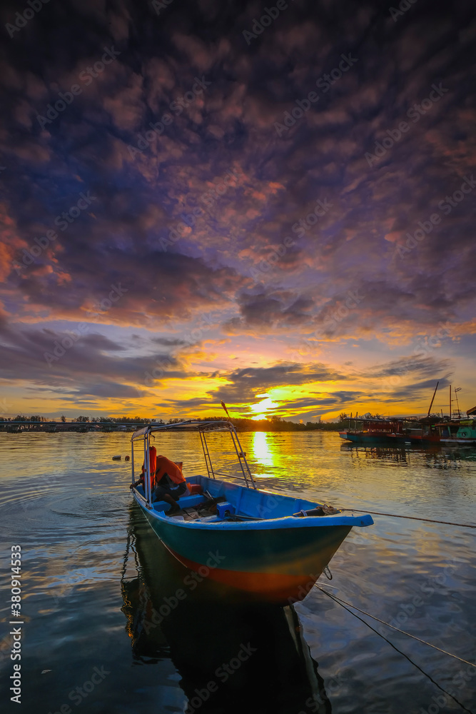 Obraz premium Parked fishing boat during sunset at Kuala Besut