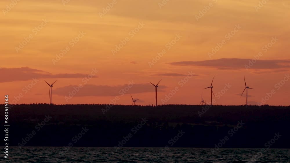 Several wind turbines moving in the wind during sunset in Sweden in a forest. Several wind turbines moving in the wind during sunset in Sweden in a forest.