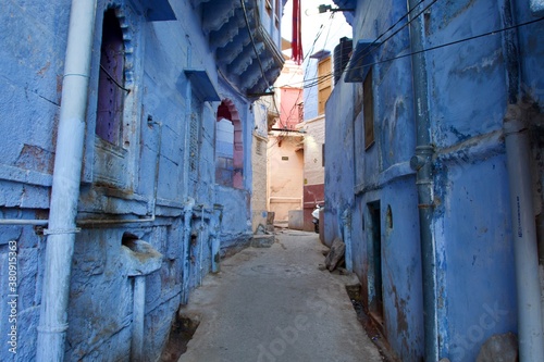 narrow street with blue houses in Jodhpur, Rajasthan, India  © Soldo76