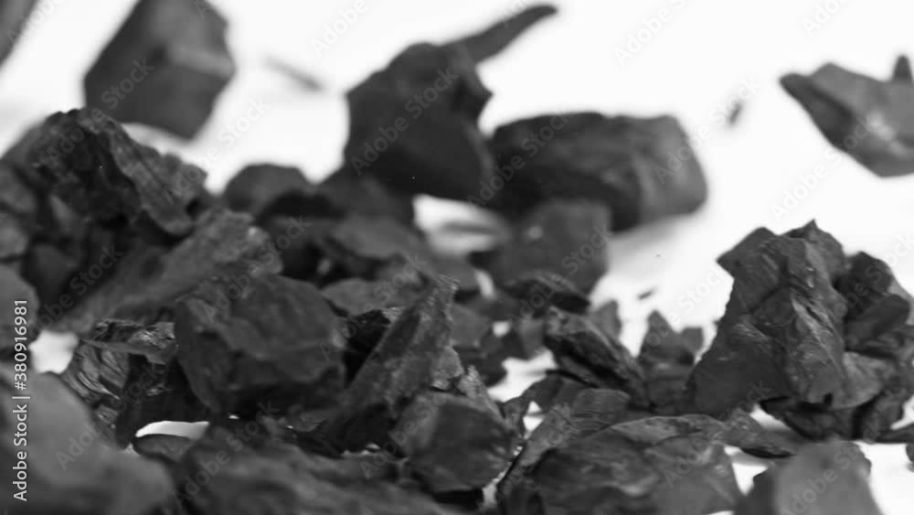 Super Slow Motion Shot of Coal Falling on White Background at 1000 fps.