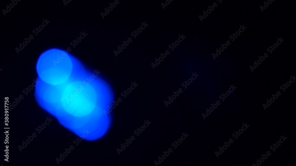 Abstract blurred blue strobe light moving through black background Abstract blurred blue strobe light moving through black background