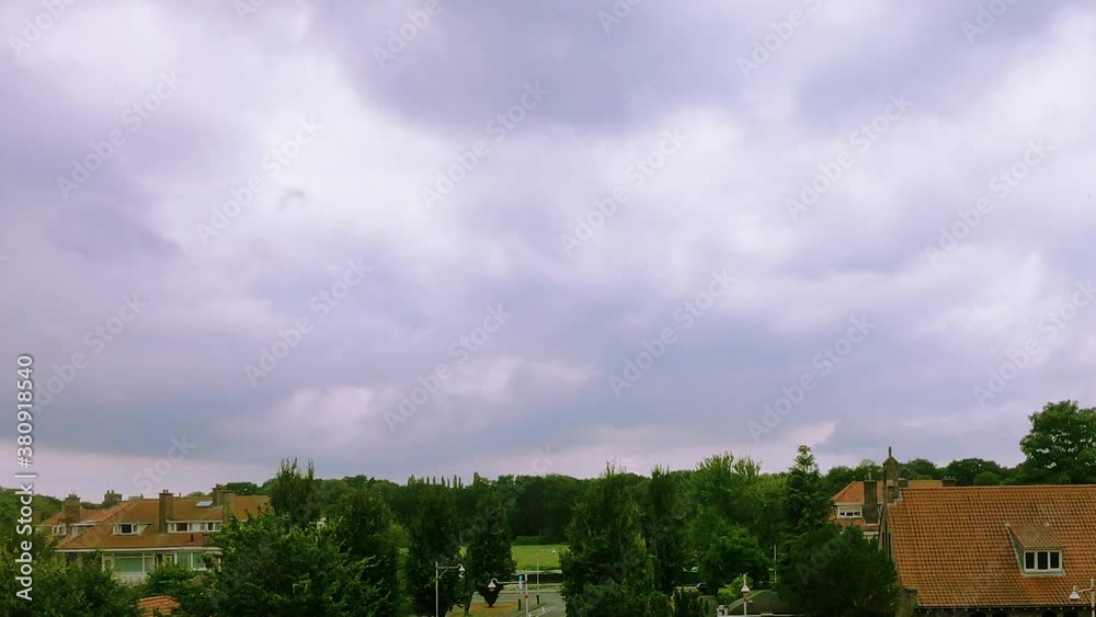 Time Lapse of residential area in The Hague, dark clouds moving over houses Time Lapse of residential area in The Hague, dark clouds moving over houses