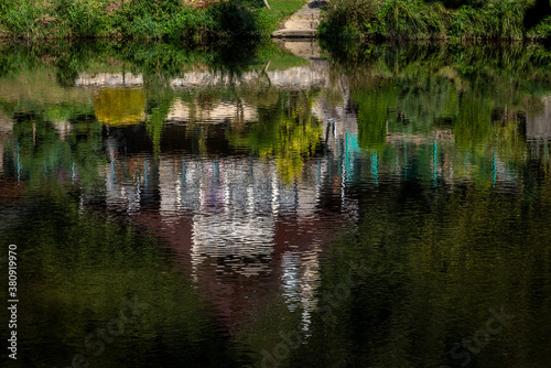 cottage on the river bank reflected on the surface
