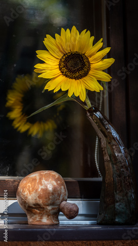 sunflowers in a ceramic vase bent down