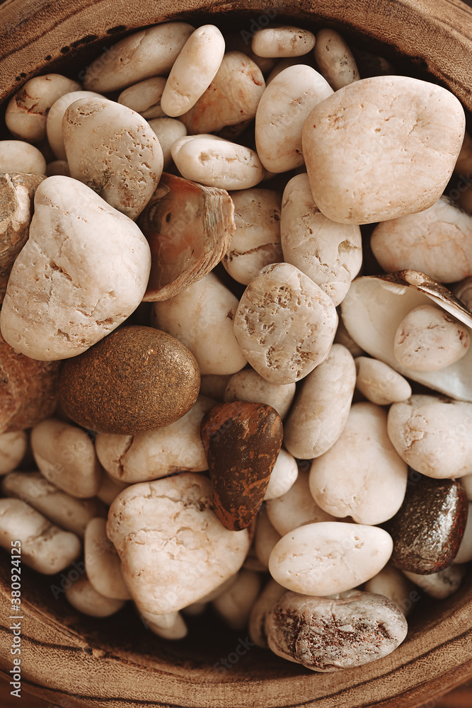 Close up decorative stones of different beige shades on a wooden plate. Top view Close up decorative stones of different beige shades on a wooden plate. Top view