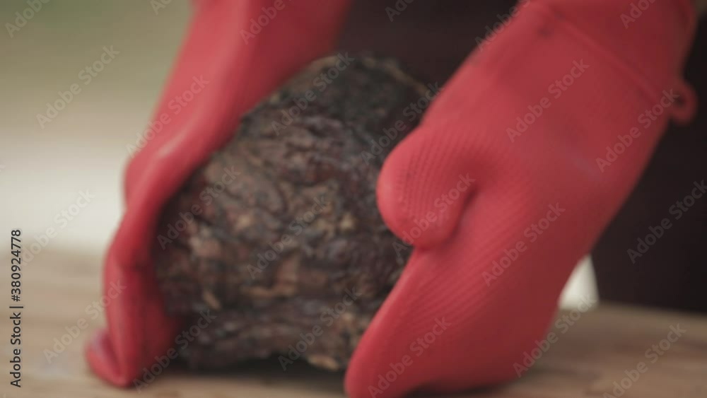 Man wearing gloves removes prime rib from grill in the backyard Man wearing gloves removes prime rib from grill in the backyard
