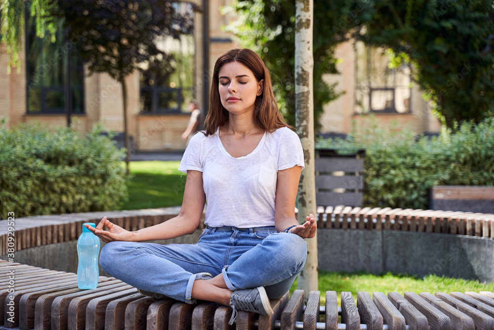 Girl trying meditation at the street Girl trying meditation at the street