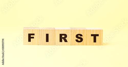 word first with black letters on wooden blocks on yellow