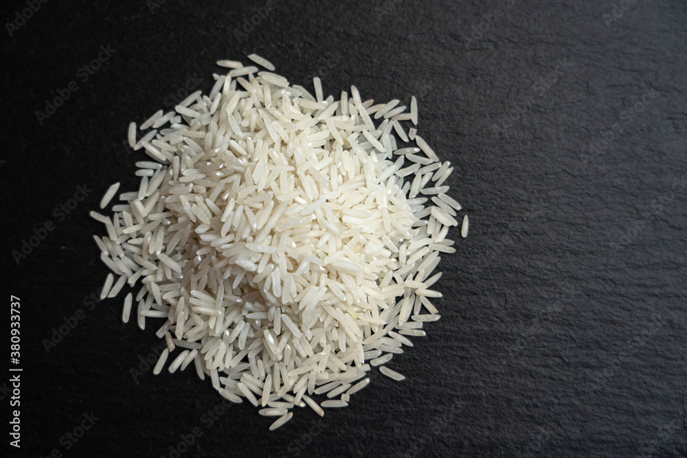 Raw basmati rice on black background with copy space, top view