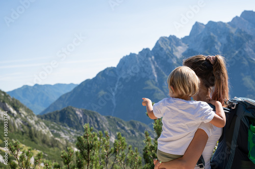 Young mother and toddler daughter looking at beautiful view in mountains